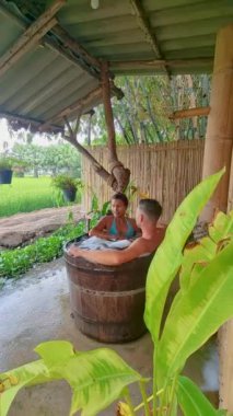 Tayland 'ın orta kesimindeki yeşil çeltik tarlaları olan Bambu kulübesinin küvetinde bir çift erkek ve kadın. 