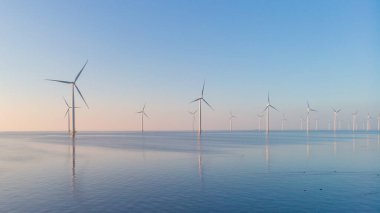 Bulutları ve mavi gökyüzü olan off-shore yel değirmeni parkı, rüzgar türbini Flevoland Hollanda 'nın deniz manzaralı yel değirmeni parkı Ijsselmeer. Yeşil enerji 