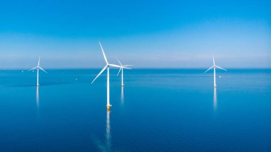 Bulutları ve mavi gökyüzü olan off-shore yel değirmeni parkı, rüzgar türbini Flevoland Hollanda 'nın deniz manzaralı yel değirmeni parkı Ijsselmeer. Yeşil enerji 