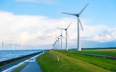 Yağmurlu bir günde bulutlu yel değirmeni parkı, rüzgâr türbini Flevoland Hollanda Ijsselmeer ile okyanus havası manzaralı yel değirmeni parkı. Yeşil enerji 
