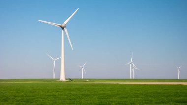Kıyıdan uzak yel değirmeni parkı ve mavi bir gökyüzü, okyanus havası manzaralı rüzgar türbini Flevoland Hollanda Ijsselmeer. Yeşil enerji kavramı