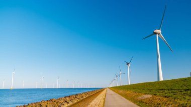 Açık deniz yel değirmeni parkı bulutlu ve mavi gökyüzü, okyanus havası manzaralı rüzgar türbini Flevoland Hollanda Ijsselmeer. 