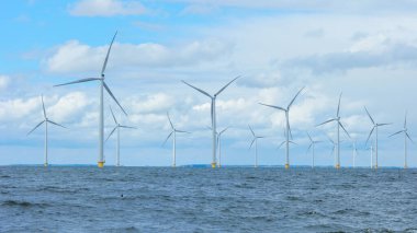Bulutları ve mavi gökyüzü olan off-shore yel değirmeni parkı, rüzgar türbini Flevoland Hollanda 'nın deniz manzaralı yel değirmeni parkı Ijsselmeer. Yeşil enerji 