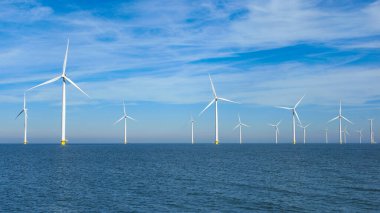 Flevoland Hollanda 'daki Ijsselmeer' de rüzgar türbinleriyle okyanus manzaralı yel değirmeni parkı. Yeşil enerji 
