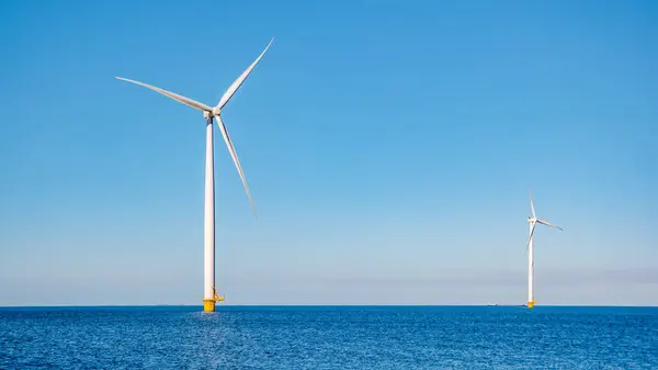 stock image offshore windmill park with clouds and a blue sky, windmill park in the ocean aerial view with wind turbine Flevoland Netherlands Ijsselmeer. Green energy production in the Netherlands