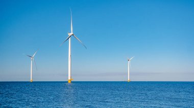 Bulutları ve mavi gökyüzü olan off-shore yel değirmeni parkı, rüzgar türbini Flevoland Hollanda 'nın deniz manzaralı yel değirmeni parkı Ijsselmeer. Hollanda 'da yeşil enerji üretimi