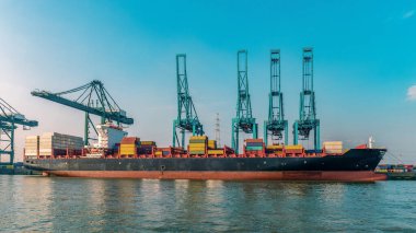 Antwerp, Belçika, Antwerp limanının en büyük rıhtımındaki vinç ve konteyner gemilerinin görüntüsü. Limanda konteynırlarla dolu büyük bir konteyner gemisi var.