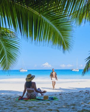 Anse Lazio Praslin Seychelles, a young couple of men and women on a tropical beach during a luxury vacation in Seychelles. Tropical beach Anse Lazio Praslin Seychelles