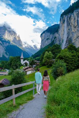 Arka planda muhteşem bir şelale ve İsviçre Alpleri olan Lauterbrunnen Vadisi 'ni ziyaret eden çift, Berner Oberland, İsviçre, Avrupa. 