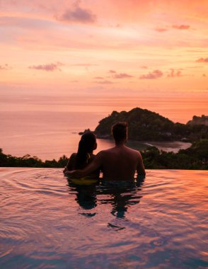  Bir çift adam ve bir kadın Tayland 'da havuz kenarında lüks bir tatil yapıyorlar. Bir çift de Tayland' da tropik bir adada balayına çıkıp okyanusu seyrediyorlar.