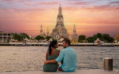 Tayland 'da gün batımında Bangkok' taki Wat Arun Tapınağı. Gün batımında Chao Praya Nehri. Bir çift erkek ve kadın Bangkok Tayland 'a geziye gittiler.