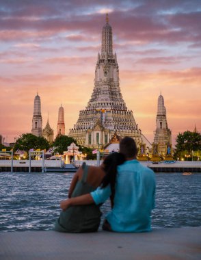 Tayland 'da gün batımında iki erkek ve bir kadın Bangkok, Wat Arun Tapınağı Bangkok' a şehir gezisine gittiler. Gün batımında Chao Praya Nehri.