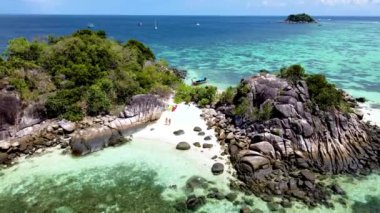 Koh Lipe Adası 'nın önündeki Kla Adası sahilinde, Güney Tayland' da turkuaz renkli okyanus ve Koh Lipe 'de güneşli bir günde Ko Lipe' de kayak yapan beyaz kumlu plaj çifti.