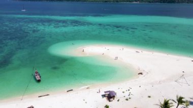 Koh Lipe Adası Tayland. Mavi okyanusu ve yumuşak beyaz kumuyla tropikal bir ada. Ko Lipe Adası Tayland. Erkekler ve kadınlar kumsalda dinlenip okyanusa bakıyorlar.