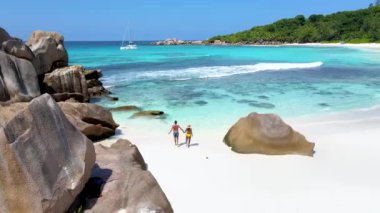 Anse Cocos, La Digue Seyşeller, Seyşeller 'de lüks bir tatil sırasında tropikal plaj. Plajda yürüyen olgun kadın ve erkekler Anse Cocos, La Digue Seyşeller