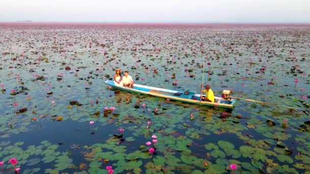位于泰国乌顿萨尼农哈恩湖红莲海的日出 在日出时分 在泰国的红荷花湖上 一对男女乘坐木船从无人驾驶飞机上看到了 — 图库视频影像