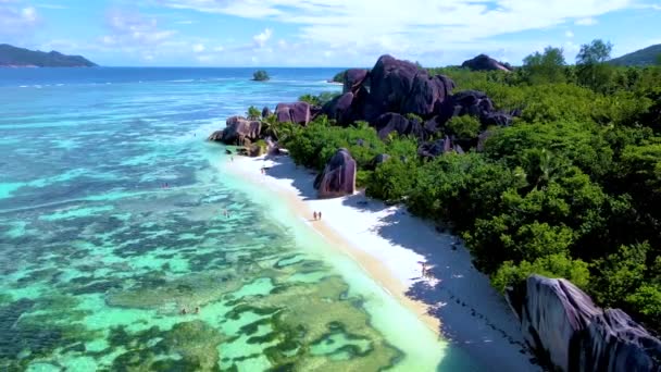 アンセスソース Dargent Digue Seychelles セーシェルで豪華な休暇中にトロピカルビーチ 成熟した男女のカップル 休日の晴れた日にビーチを歩く — ストック動画