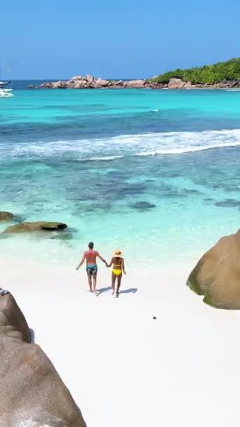 アンセコスビーチ ラディグセイシェル セイシェルの豪華な休暇中にトロピカルビーチ 成熟した男女のカップル ビーチを歩く トロピカルビーチアンセコス Digue Seychelles — ストック動画
