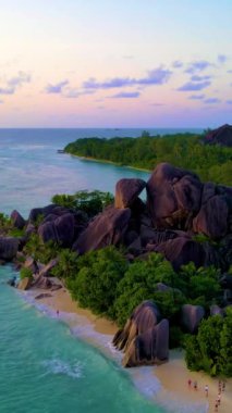 Anse Source dArgent, La Digue Seyşeller, Seyşeller 'de lüks bir tatil sırasında tropikal plaj. Tropik sahil Anse Source dArgent, La Digue Seyşeller gün batımında güzel renkli gökyüzü