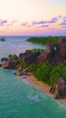 Anse Source dArgent, La Digue Seyşeller, Seyşeller 'de lüks bir tatil sırasında tropikal plaj. Tropik sahil Anse Kaynak dArgent, La Digue Seyşeller gün batımında turuncu gökyüzü