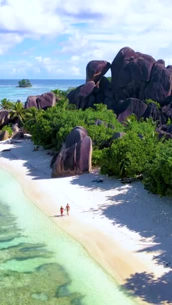 アンセスソース Dargent Digue Seychelles セーシェルで豪華な休暇中にトロピカルビーチ 成熟した男女のカップル セーシェルでビーチを歩く — ストック動画