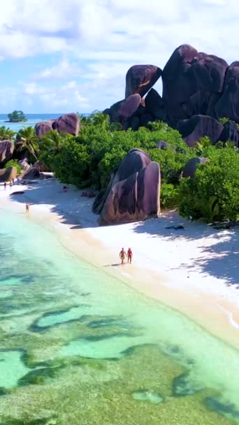 一对夫妇在塞舌尔拉迪古塞舌尔的昂斯之源达金特海滩散步 在一个豪华度假的热带海滩上散步 两个成熟的男人和女人在海滩上散步 — 图库视频影像