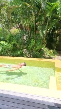 Koh Kood Tayland tropikal adasındaki havuzda havuz kenarında dinlenen bir adam.