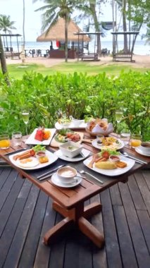 Plajda okyanus manzaralı lüks kahvaltı masası. Tayland 'da lüks bir otel. Ekmek, yumurta, kahve ve meyve suyu olan bir kahvaltı masası.