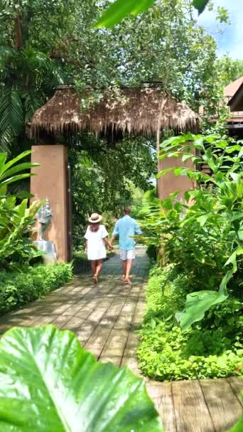 コッド島タイトラットの高級ホテルのトロピカルガーデンで歩く男女のカップル — ストック動画