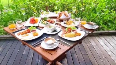 Plajda okyanus manzaralı lüks kahvaltı masası. Tayland 'da lüks bir otel. Ekmek, yumurta, kahve ve meyve suyu olan bir kahvaltı masası.