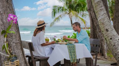 Koh Kood Tayland sahilinde romantik bir akşam yemeği. Orta yaşlı bir kadın ve erkek. Tayland sahilinde yemek yiyen bir Avrupalı. 