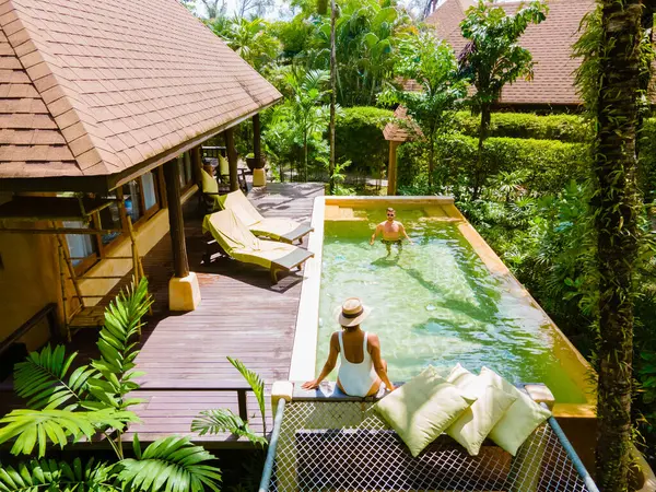 ビーチのモダンなプールヴィラ タイのラグジュアリーヴィラ プールでリラックスした5つ星リゾートでタイで豪華な休暇を過ごす男性と女性 — ストック写真