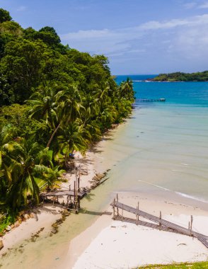 Bang Bao Plajı 'ndaki ahşap köprü Koh Kood Adası Trat, palmiye ağaçları ve turkuaz renkli okyanuslu tropikal plaj, kumsalda hindistan cevizi palmiyeleri olan Ko Kut Adası.,