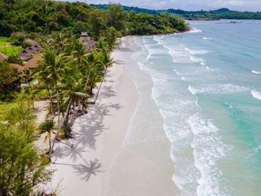 Beyaz Sahil Koh Kood Adası Tayland Trat, güneşli bir günde palmiye ağaçları ve turkuaz renkli okyanuslu tropikal plaj, Ko Kut Adası sahilinde hindistan cevizi palmiyesi ağaçları, insansız hava aracı hava aracı manzaralı deniz.