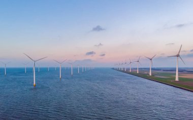 Rüzgâr türbini Flevoland Hollanda Ijsselmeer ile okyanus manzaralı Windmill Parkı 'nda gün batımı. Hollanda 'da Yeşil Enerji Üretimi