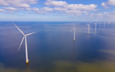 Bulutlu ve mavi gökyüzü olan yel değirmeni parkı, rüzgâr türbini Flevoland Hollanda 'nın deniz manzaralı yel değirmeni parkı. Hollanda 'da yeşil enerji üretimi