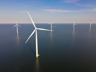 Bulutları ve mavi gökyüzü olan bir yel değirmeni parkının yukarıdan görünüşü, okyanus havası manzaralı rüzgar türbini Flevoland Hollanda Ijsselmeer ile birlikte. Hollanda 'da Yeşil Enerji Üretimi