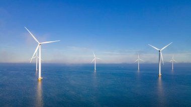 Rüzgâr türbini Flevoland Hollanda 'dan Ijsselmeer ile okyanus manzaralı yel değirmeni parkı. Hollanda 'da Yeşil Enerji üretimi