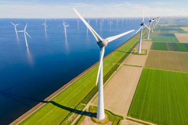 Yeşil buğday tarlasında elektrik üretimi için yel değirmenleri grubu