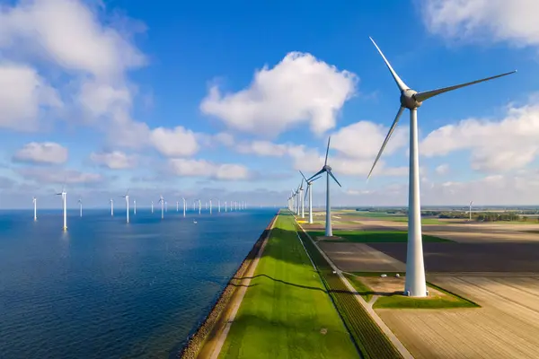Turbine Green Energy Electricity, Windmill for electric power production, Wind turbines generating electricity on a green agricultural field in the Netherlands by the lake Ijsselmeer, green energy