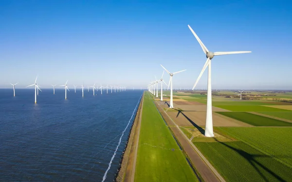Turbine Green Energy Electricity, Windmill for electric power production, Wind turbines generating electricity on a green agricultural field in the Netherlands by the lake Ijsselmeer