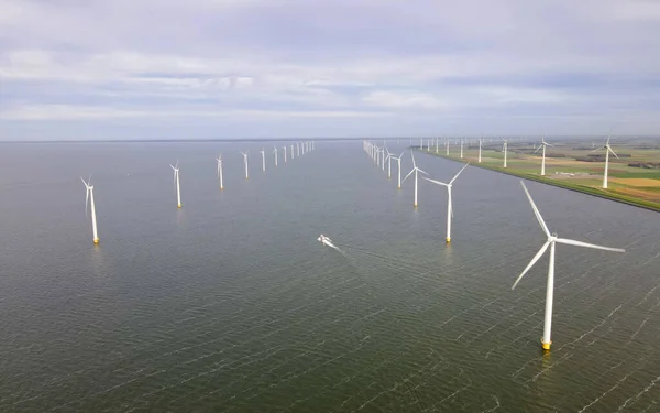 暗い灰色の空に対して嵐の海で風力タービン 持続可能なエネルギー生産 クリーンエネルギー 再生可能エネルギーコンセプト — ストック写真