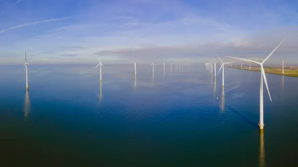 Wind Farm. Windmill farm in the ocean. Offshore wind turbines in the sea. Wind turbine from an aerial view