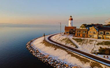 Hollanda Deniz Feneri 'nde gün batımı. Hollanda' da kış boyunca kar yağarken..