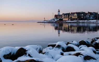 Hollanda 'nın Urk deniz feneri kışın Hollanda' da karla kaplı ve suda güzel bir yansıması var.
