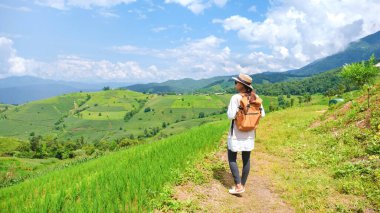 Chiangmai, Tayland 'daki Terrace Rice Field, Pa Pong Piang pirinç terasları, yağmur mevsiminde yeşil çeltik tarlaları. Gün batımında dağlarda yürüyüş yapan Asyalı kadın.