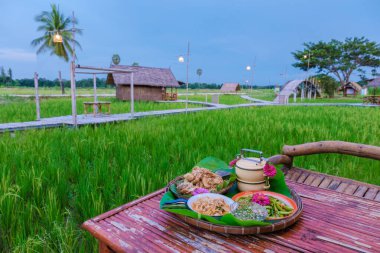 Güneş doğarken yeşil çeltik tarlasıyla Tayland kahvaltısı yeşil pirinç tarlasında pirinç çorbası.