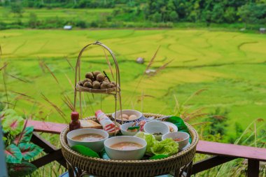Sabah kahvaltı için yeşil sarı çeltik tarlasıyla Sapan Bo Kluea Nan Tayland 'da pirinç çorbası yeşil pirinç tarlaları ve dağları olan yeşil bir vadi.