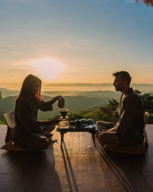 Tatilde olan bir çift sabah tatil sırasında damlayan kahveyle uyanır ve Doi Chang Chiang Rai Tayland dağlarına bakar.