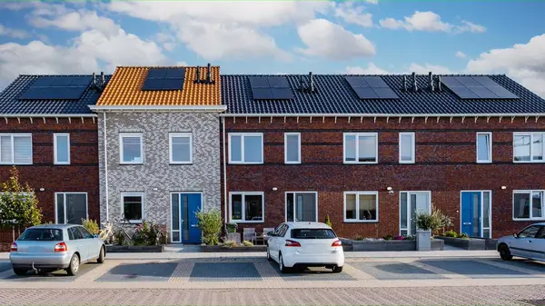 Newly build houses with solar panels attached to the roof, photovoltaics on the red roof of a house, and Alternative electricity source. Concept of sustainable resources